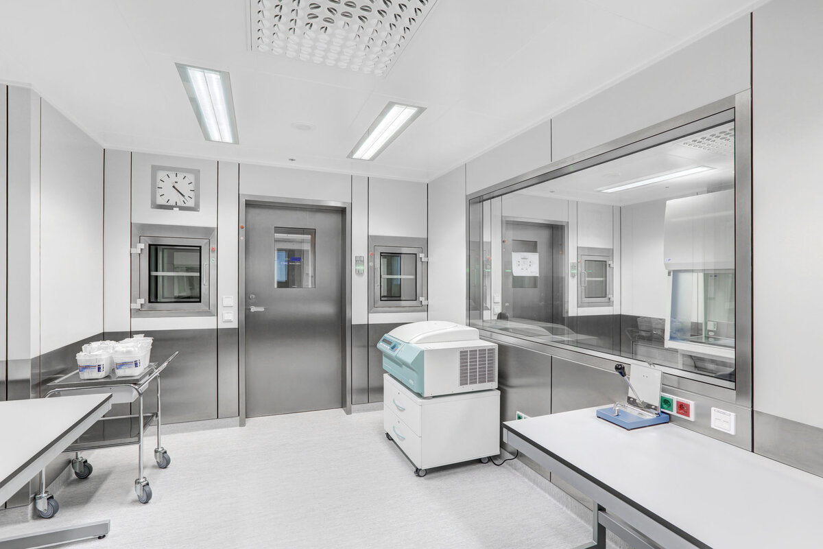 Modern medical or laboratory room with stainless steel walls and equipment.
